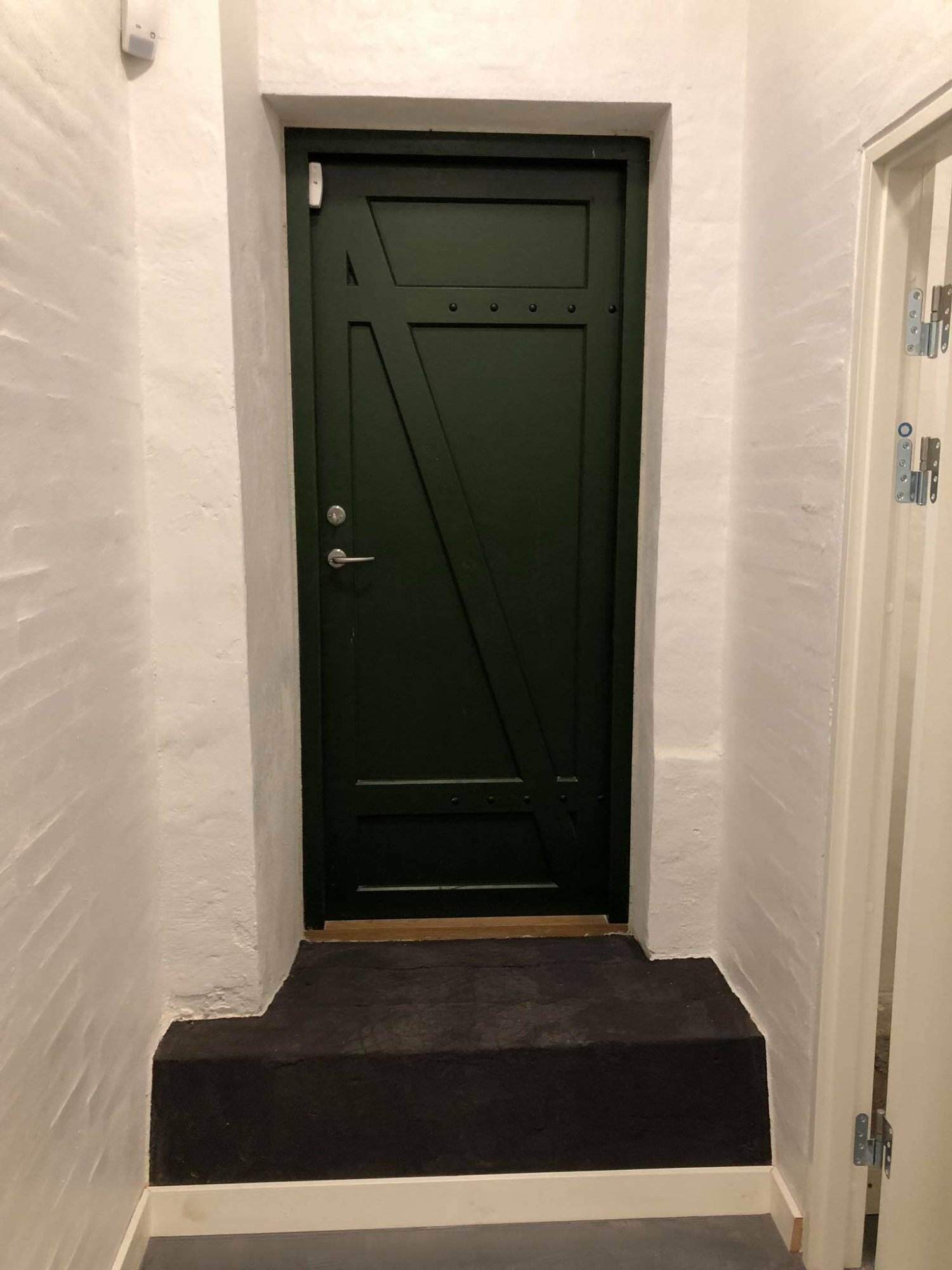 Sort træindvendig dør med moderne design.