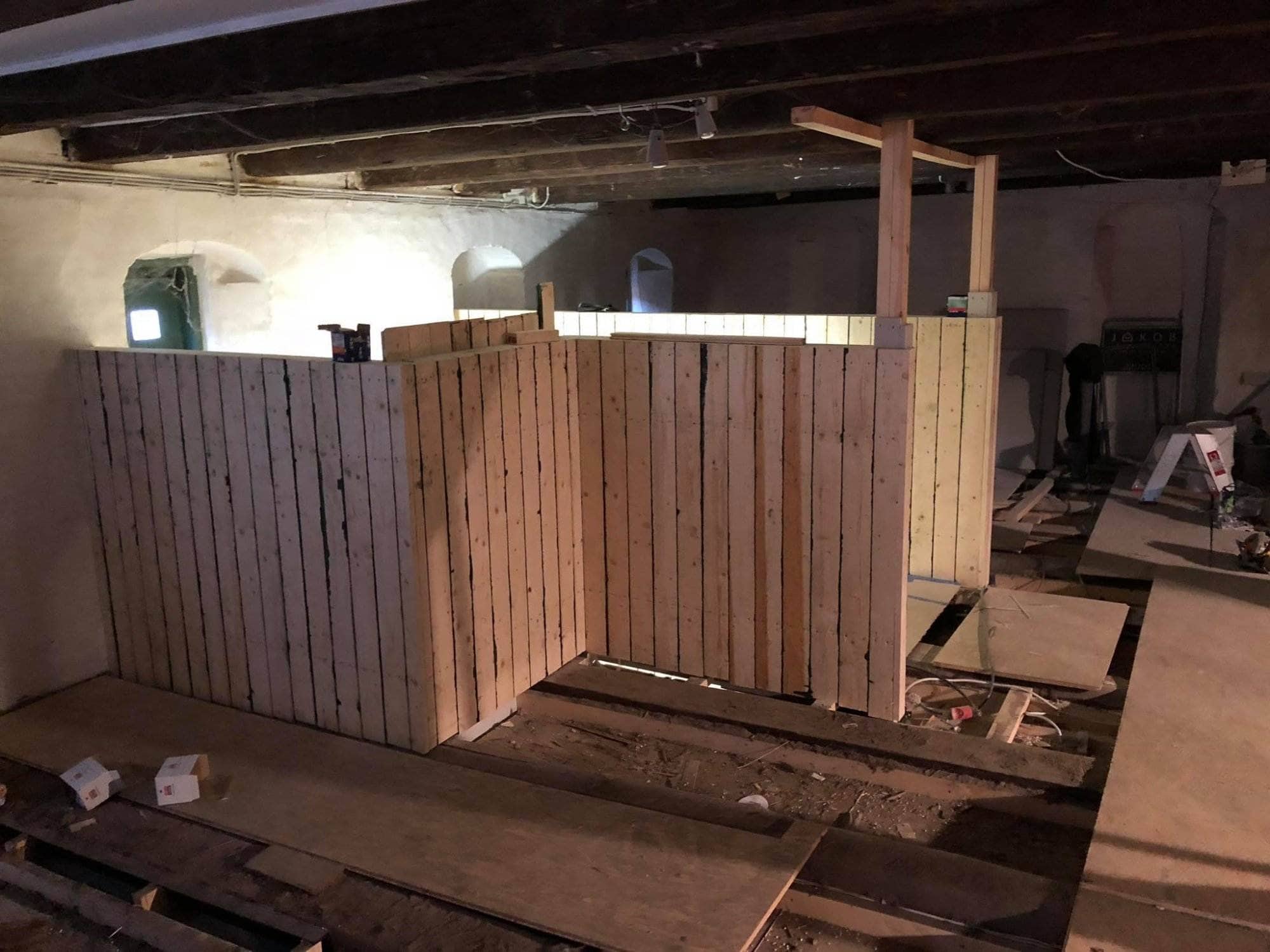 Håndværk af trævægge i kælderbyggeri, der viser tømrerarbejde til opdeling af rum.