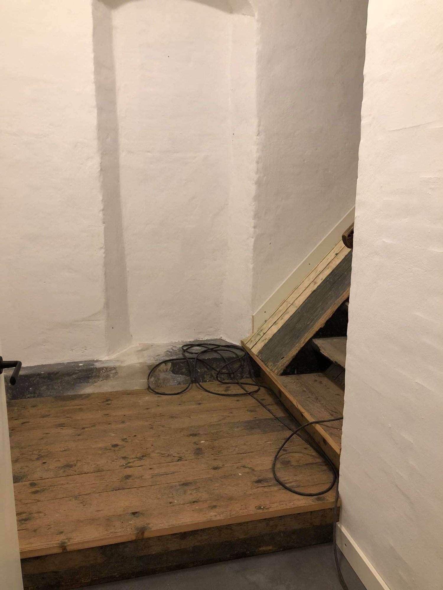 Hjemmelavet trappe i træ under opbygning i et rum.