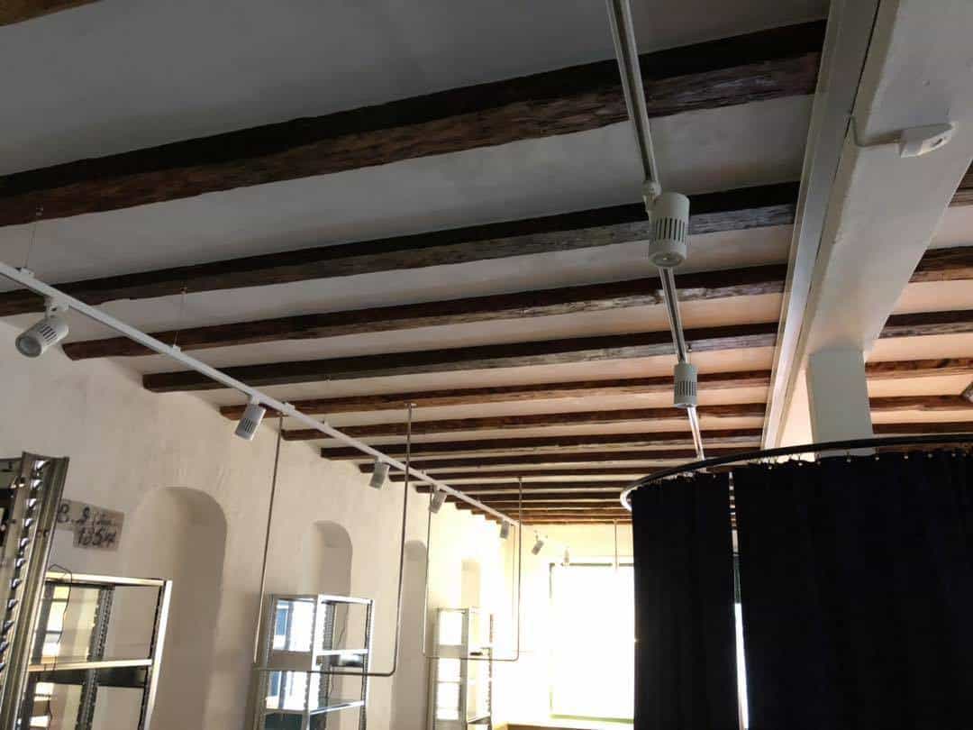 Tømrerarbejde i indendørs miljø med synlige træbjælker og loftsdetaljer.