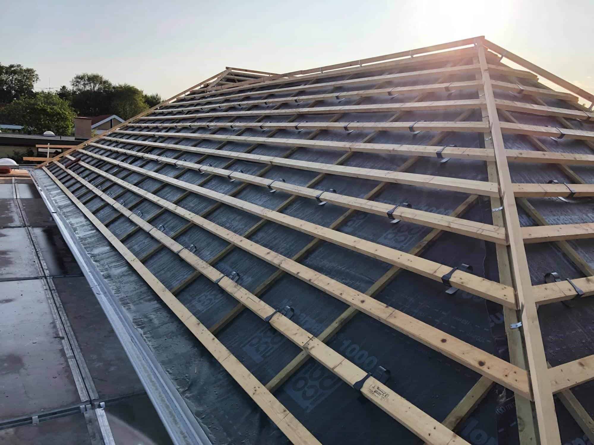 Tagkonstruktion med træspær og tagfolie under opbygning.