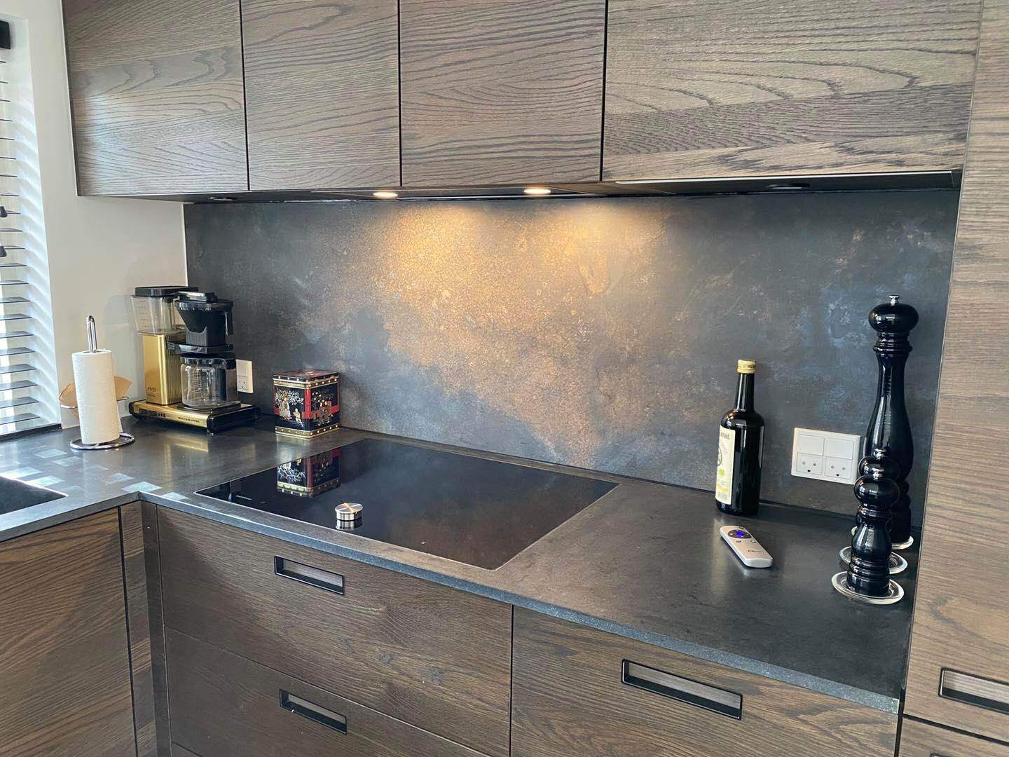 Moderne køkken med træskabslåger og sort bordplade, perfekt til moderne hjem.