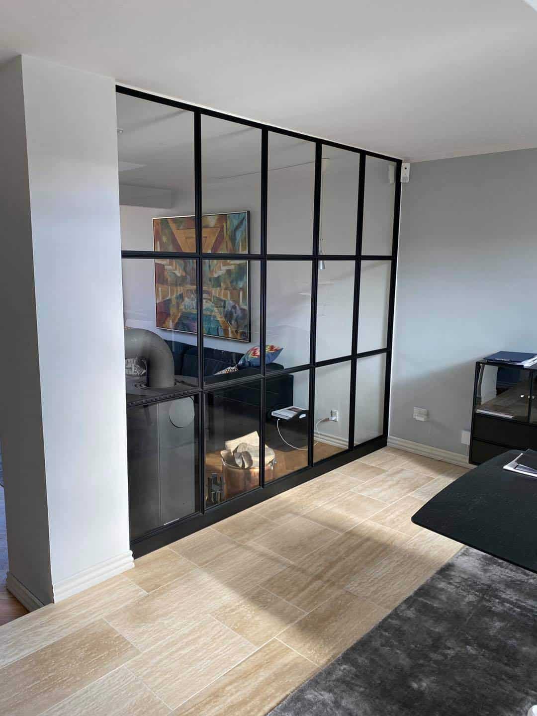 Modulvæg i sort metalramme til opdeling af rum.