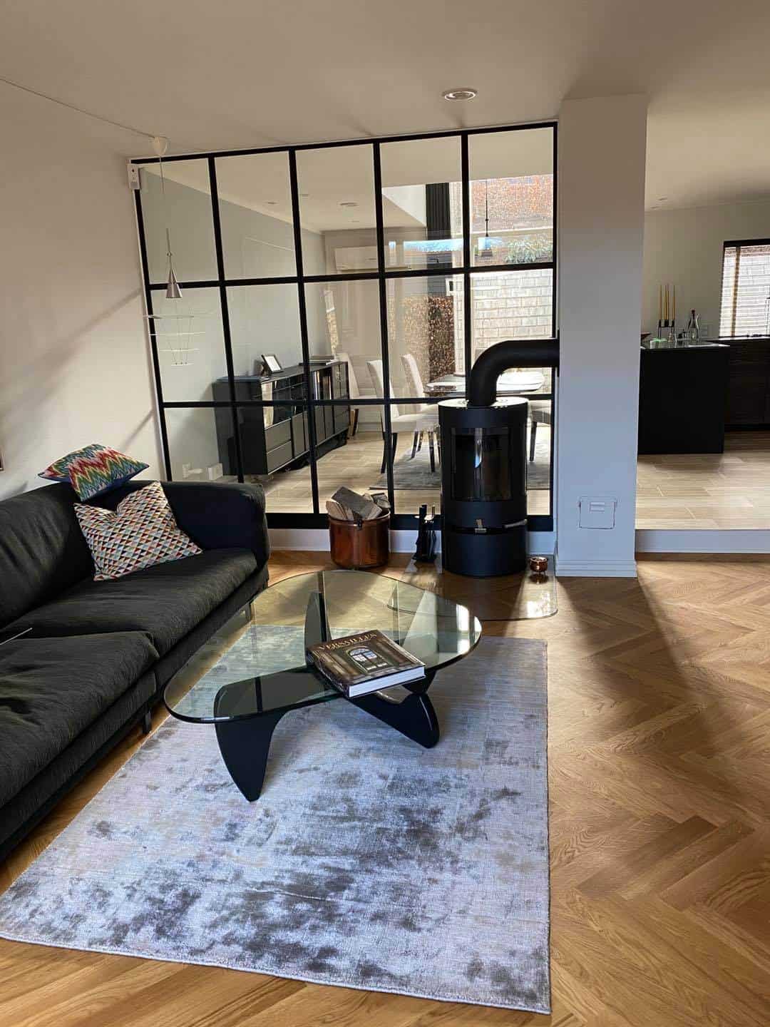 Moderne stue med glasvæg og pejs, elegant indretning og komfortabel sofa. Perfekt til afslapning i h.