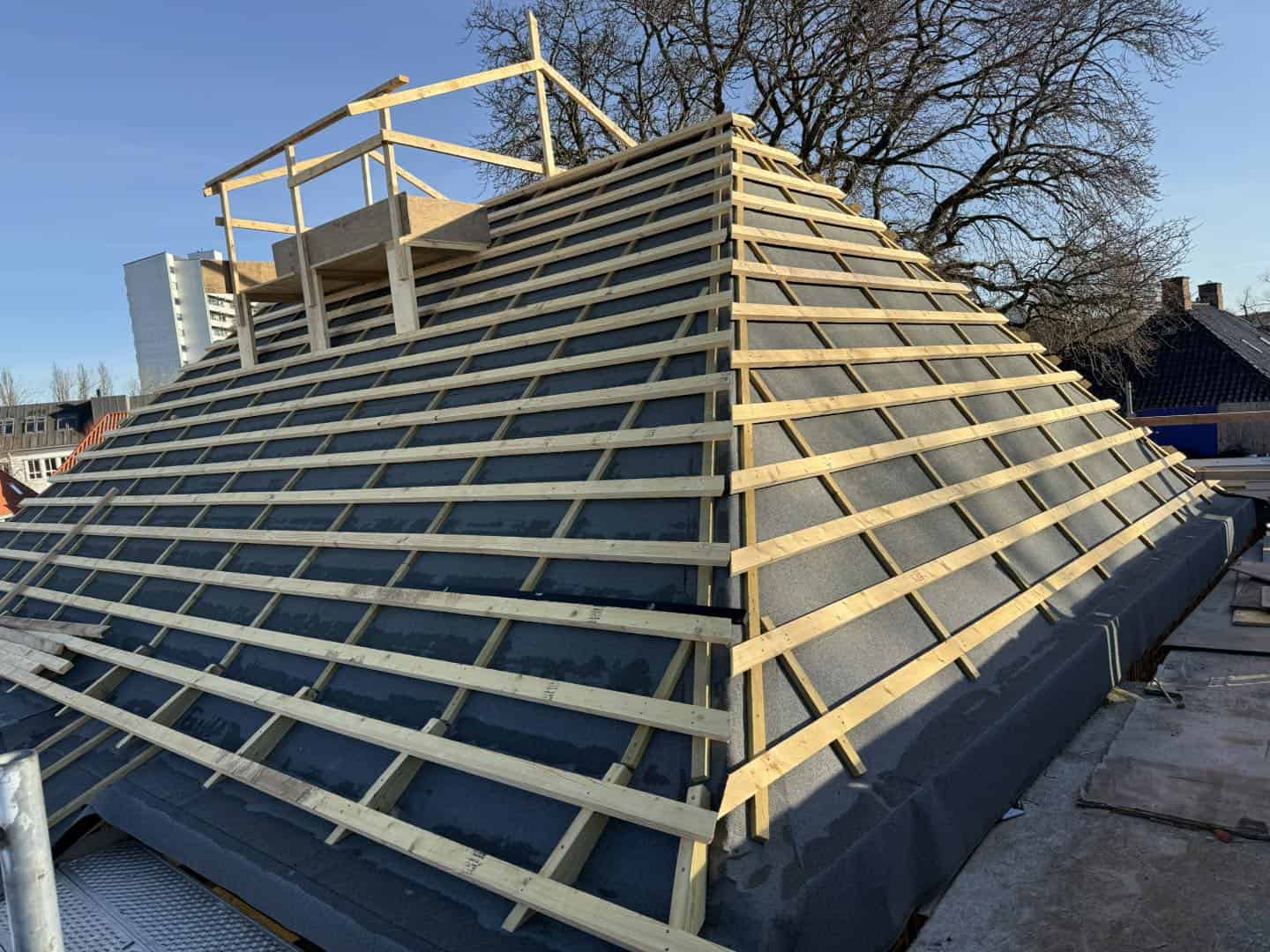 Nybygget tag med træspær og tagpap, klar til tagbelægning.