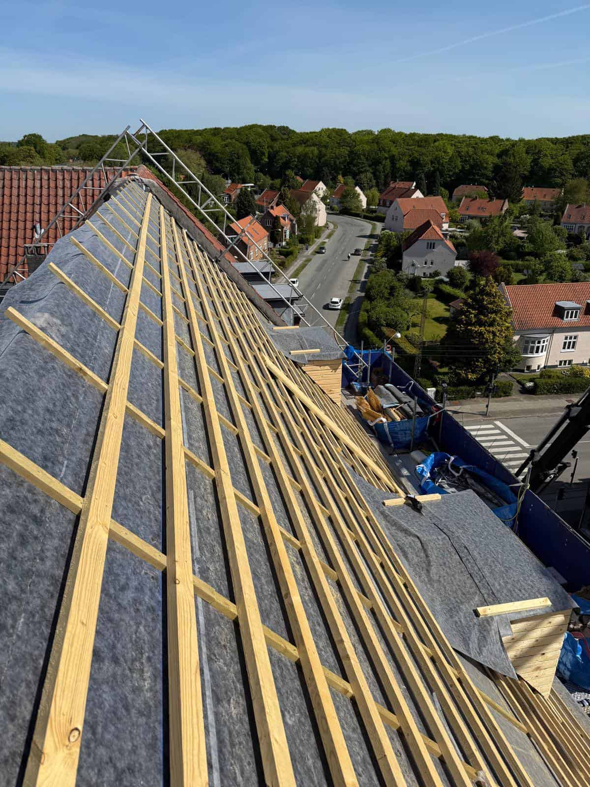 Ny tagdækning med træspær og undertag på et boligtag under konstruktion.