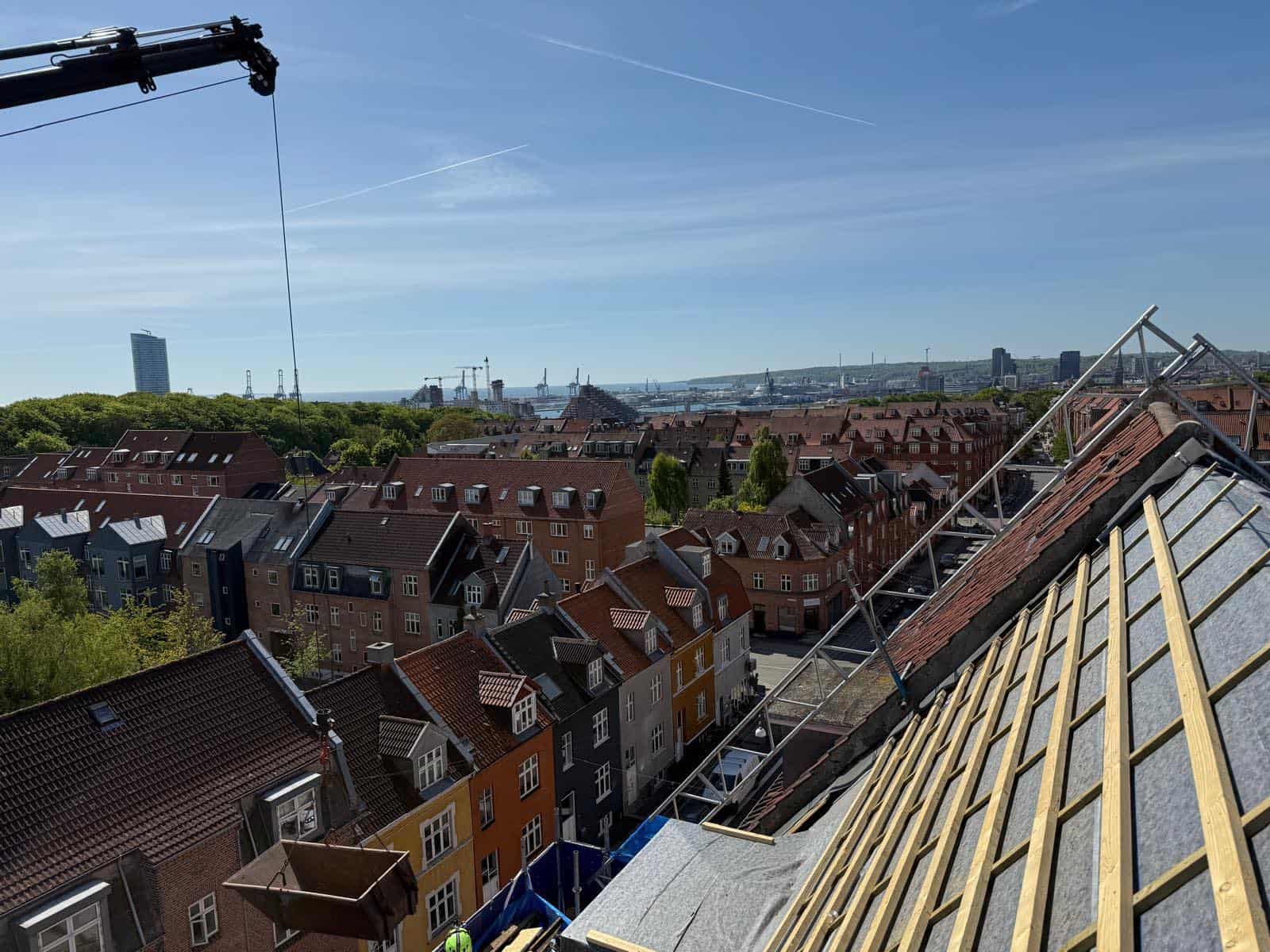 Tagkonstruktion med udsigt over byen og skyline i baggrunden.