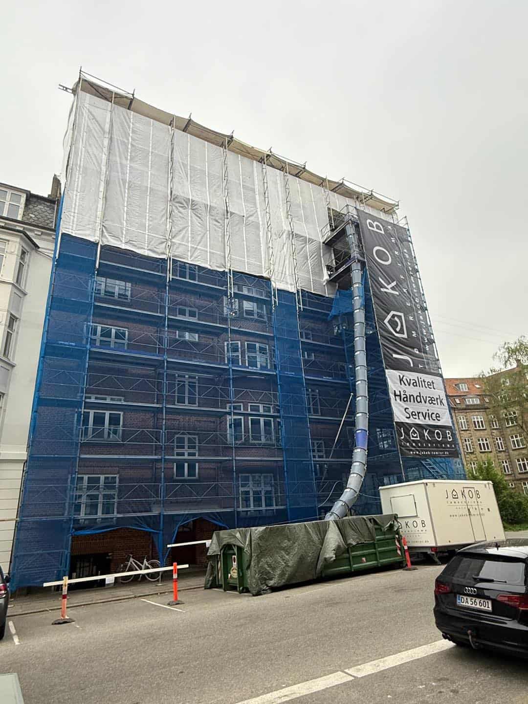 Bygningsrenovering med stillads og afdækning i København.