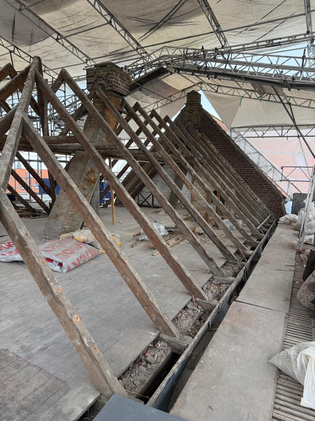 Renoveringsarbejde på tagkonstruktion med midlertidig tagdækning.