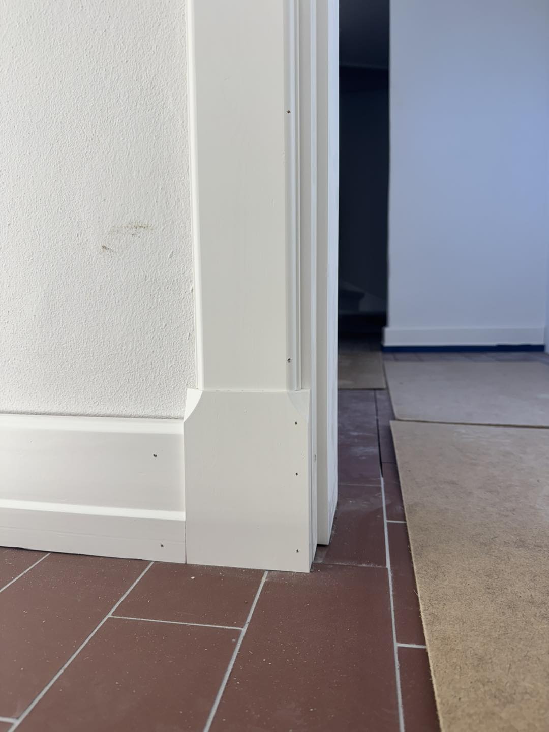 Nærbillede af hjørne med dørkarme og gulvdetaljer i et moderne hjem.