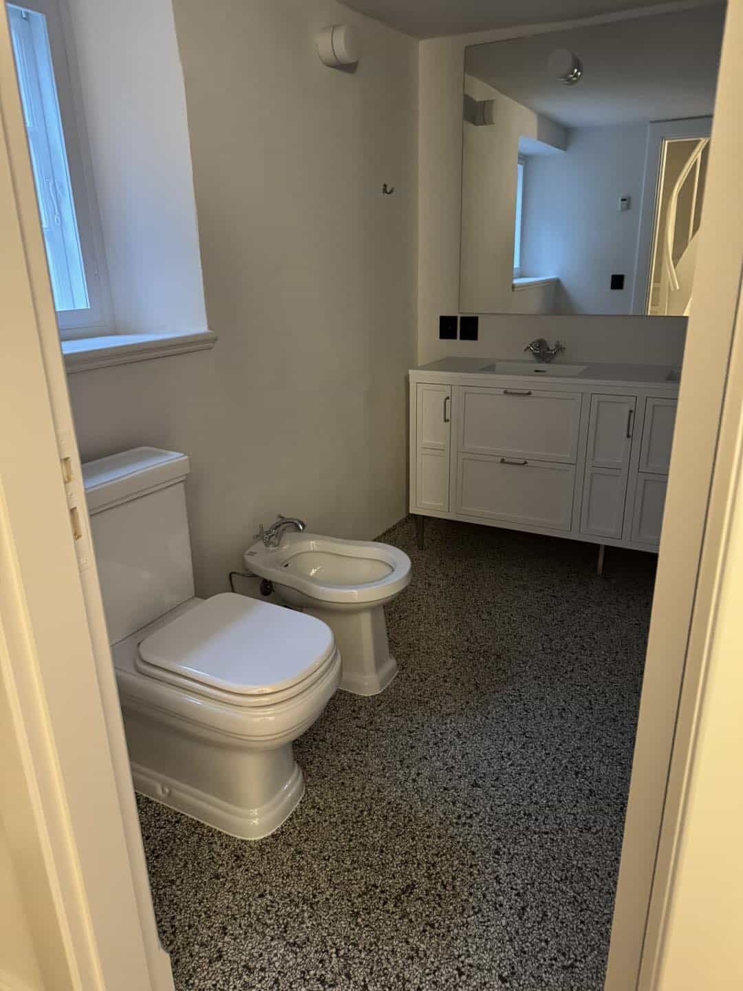 Badeværelse med toilet og vask, udført af Jakob Tømrerfirma A/S, der værner om arkitektur og kvalite.