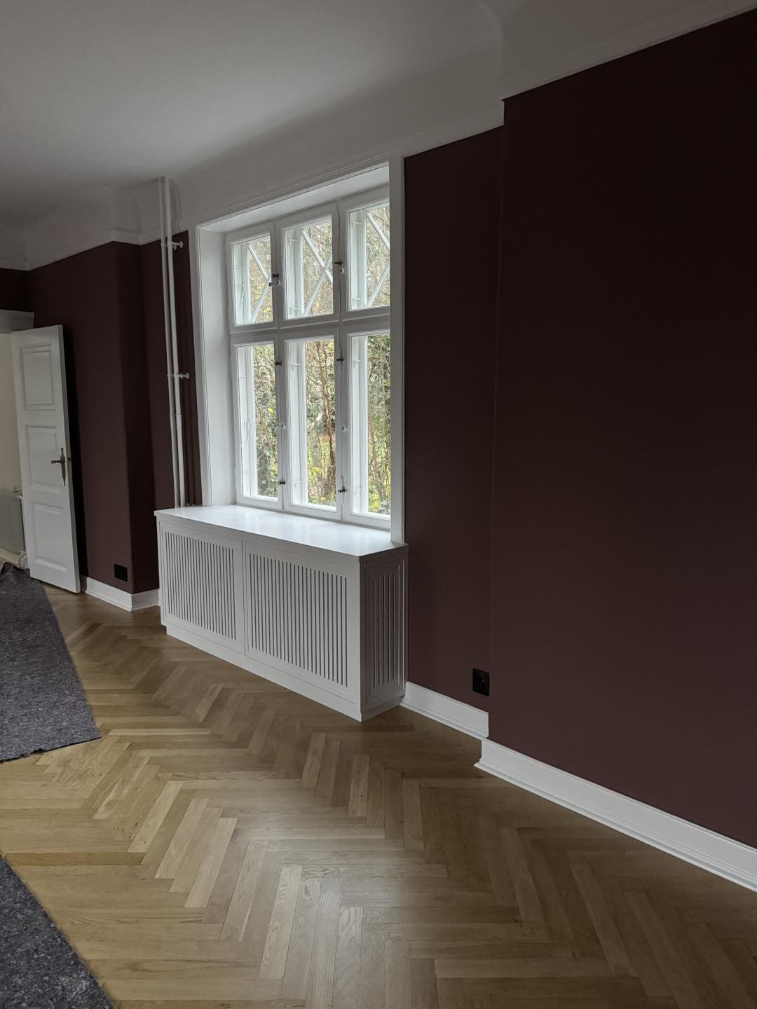 Indretning med smukke vinduesrammer og radiatorcover i et moderne hjem.